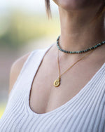 Frau trägt Halksette Gold mit Ammonit Anhänger und Naturstein Choker