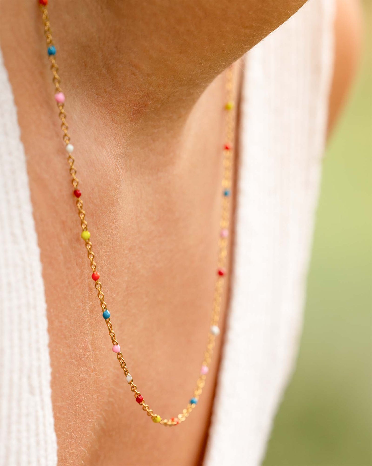 Frau trägt Halskette Gold mit farbigen Punkten