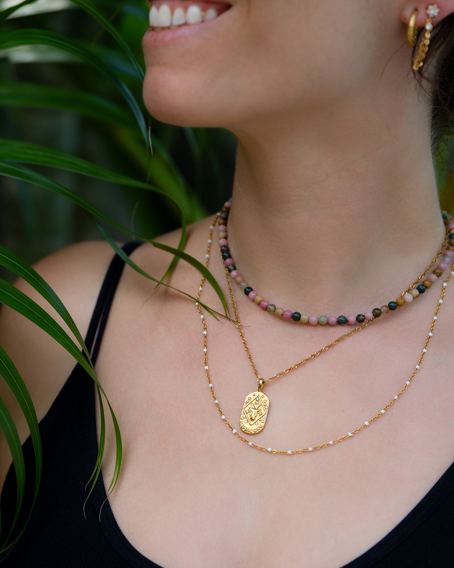 Frau trägt drei Halsketten im Layering Look