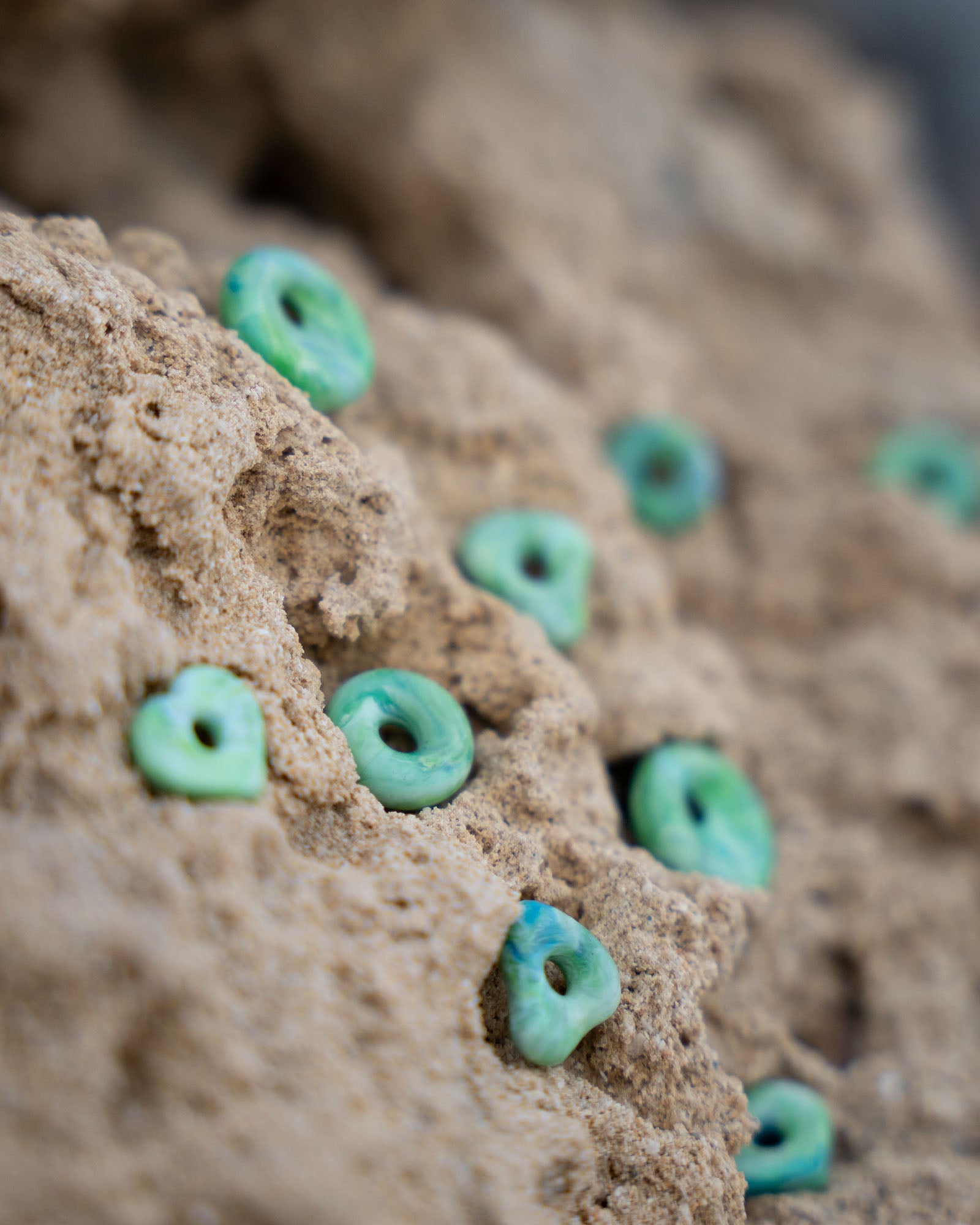 KOHO Charms in Grün aus recyceltem Plastik auf natürlichem Untergrund